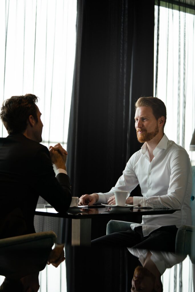 Two business people sitting at coffee shop discussing project